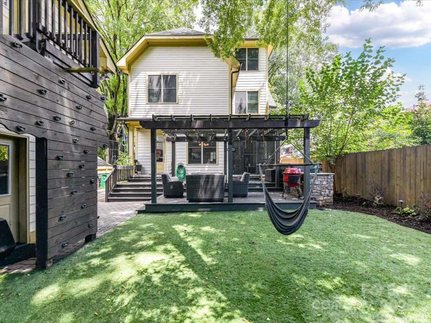 1716 Bay Street, Charlotte, NC 28204.  MLS# CAR4289594, YatesRealty ID 34826. Exterior Back of Home with great entertaining area with fenced back yard, turf, mature trees, tiered deck with pergola (perfect seating area) & in ground gas grill!