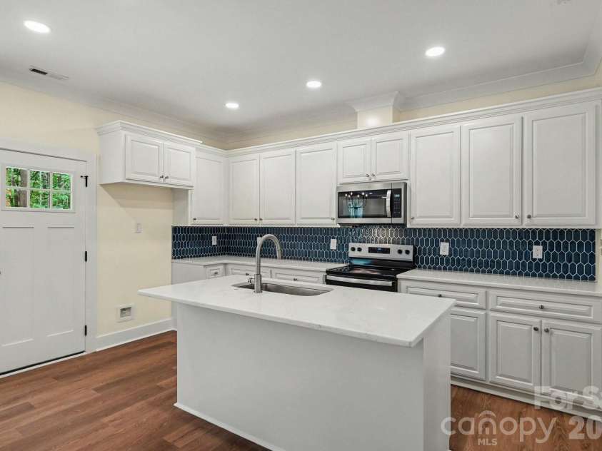 101 Delancy Street, Locust, NC 28097.  MLS# CAR4398518, YatesRealty ID 34866. Sparkling kitchen with sharp blue tiled backsplash