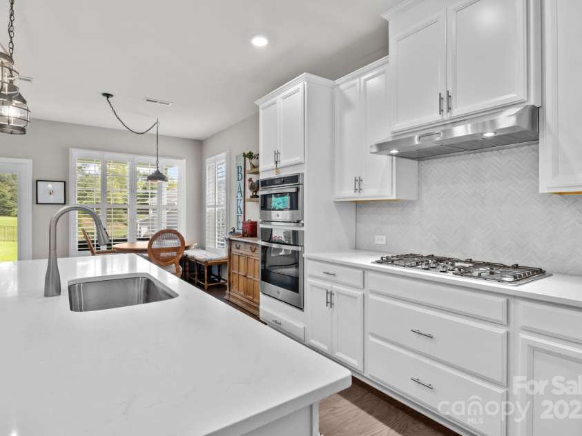 12710 Longford Crossing Place, Huntersville, NC 28078.  MLS# CAR4294654, YatesRealty ID 34868. Quartz counters, crisp white cabinets & herringbone tile backsplash