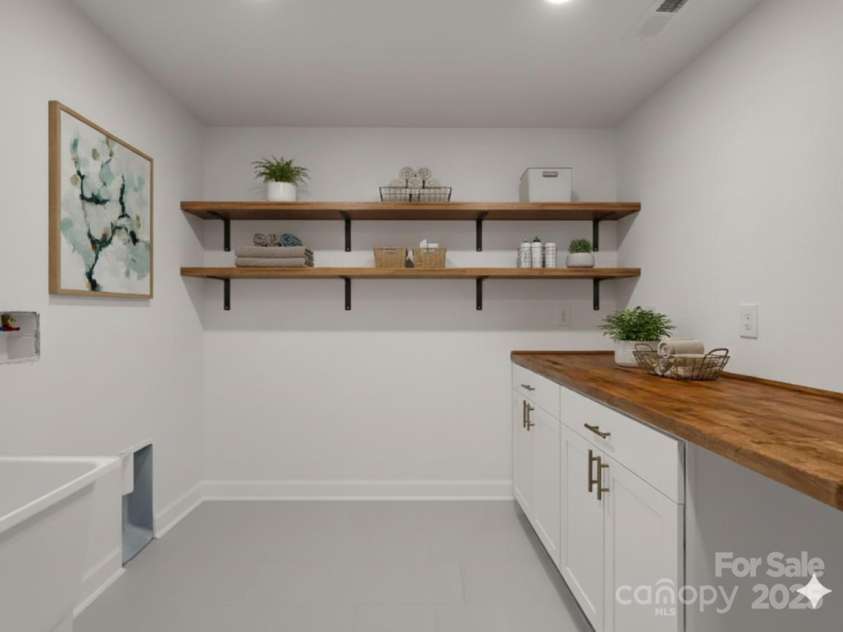 30 Patti Drive, Fletcher, NC 28732.  MLS# CAR4296193, YatesRealty ID 34869. Large laundry room with W/D hookups, utility sink and folding counter with storage. (Virtually Staged)