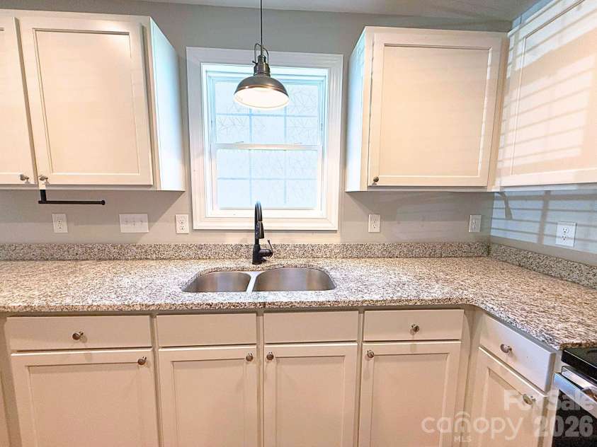 521 Johnson Street, Chester, SC 29706.  MLS# CAR4400310, YatesRealty ID 34869. Kitchen – Double-basin sink positioned beneath a window provides natural light while complementing the expansive granite workspace.