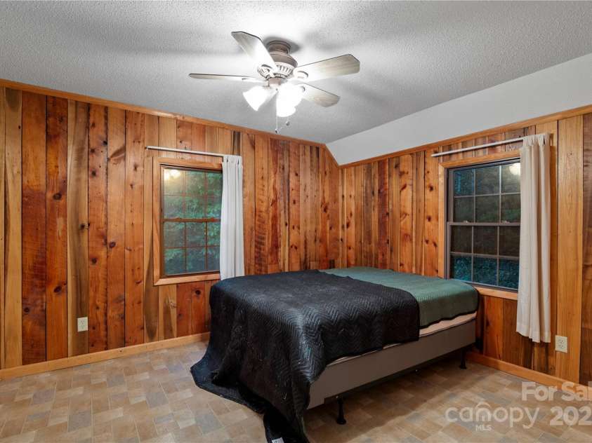 12215 Big Laurel Road, Marshall, NC 28753.  MLS# CAR4289922, YatesRealty ID 34872. Bedroom in guest cabin with rustic wood siding