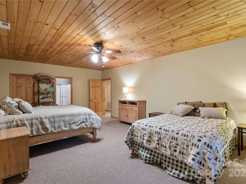 12215 Big Laurel Road, Marshall, NC 28753.  MLS# CAR4289922, YatesRealty ID 34872. Large lower level guest bedroom with tongue and groove ceilings, walk in closet and en suite full bath