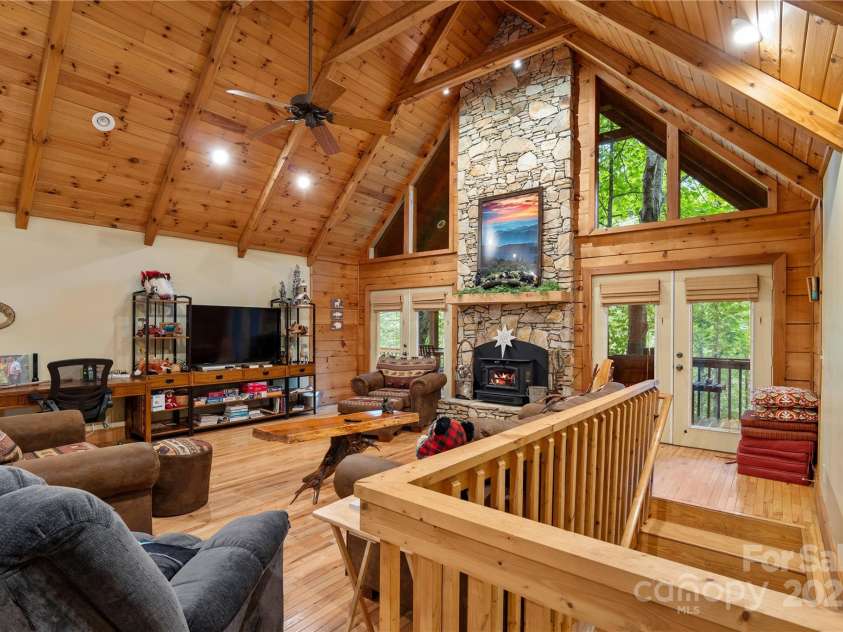 12215 Big Laurel Road, Marshall, NC 28753.  MLS# CAR4289922, YatesRealty ID 34872. Open living room with stone fireplace and woodstove insert and spacious windows