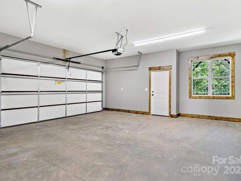 23 Laurel Crest Lane, Mill Spring, NC 28756.  MLS# CAR4294698, YatesRealty ID 34956. Garage in basement with walk through door
