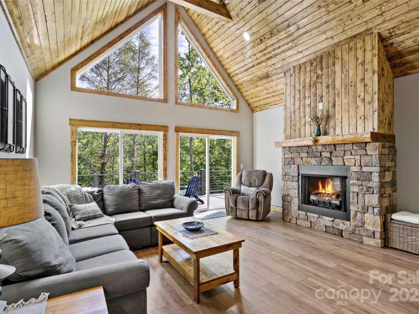 23 Laurel Crest Lane, Mill Spring, NC 28756.  MLS# CAR4294698, YatesRealty ID 34956. Living room with cozy fireplace