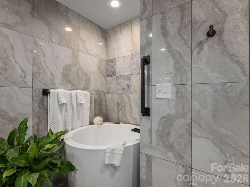 122 Brandon Road, Hendersonville, NC 28739.  MLS# CAR4391483, YatesRealty ID 34975. Spa-inspired primary bath with freestanding soaking tub surrounded by elegant tilework.