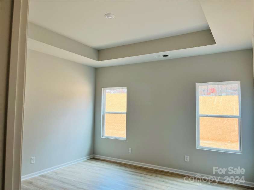 1066 Bull Dog Lane, Wingate, NC 28174.  MLS# CAR4204217, YatesRealty ID 3498. Primary bedroom with laminate flooring and tray ceiling.