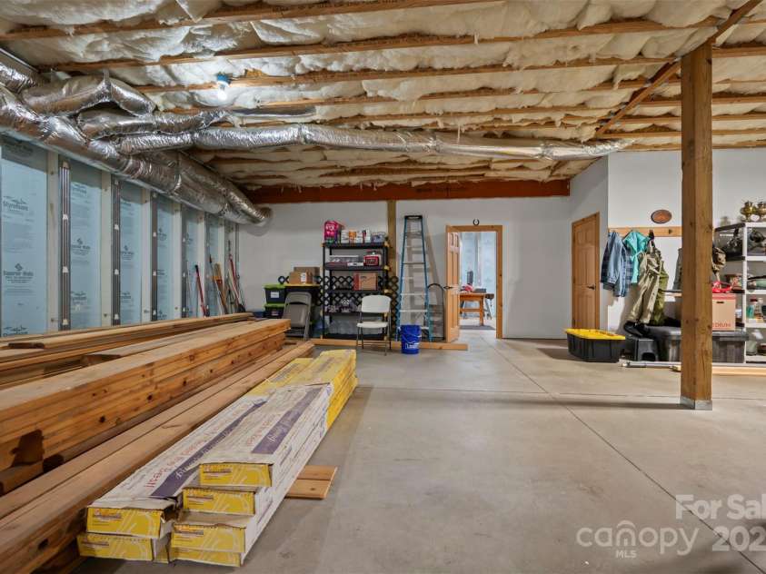 23 Jay Foster Way, Saluda, NC 28773.  MLS# CAR4278065, YatesRealty ID 35063. View to workshop area.  Door to right is storage under staircase
