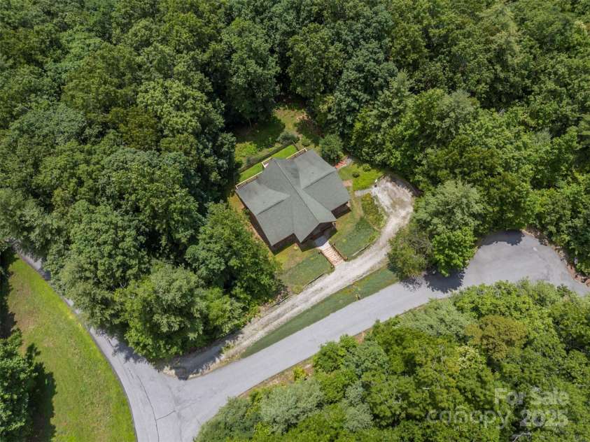 23 Jay Foster Way, Saluda, NC 28773.  MLS# CAR4323305, YatesRealty ID 35063. Aerial showing driveway to home and paved road.  Only one other home (not visible) on this cul-de-sac