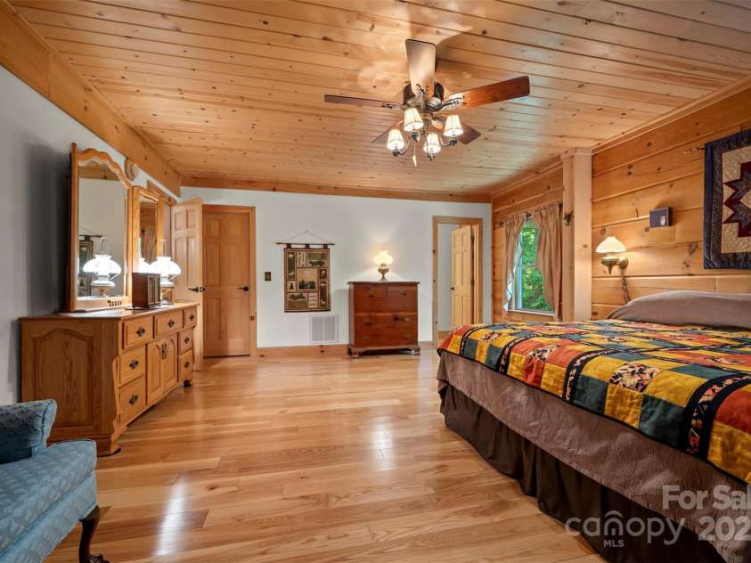 23 Jay Foster Way, Saluda, NC 28773.  MLS# CAR4323305, YatesRealty ID 35063. View 2 of primary  bedroom.  En-suite bath door is to the right.  I love the combination of wood & drywall throughtout!