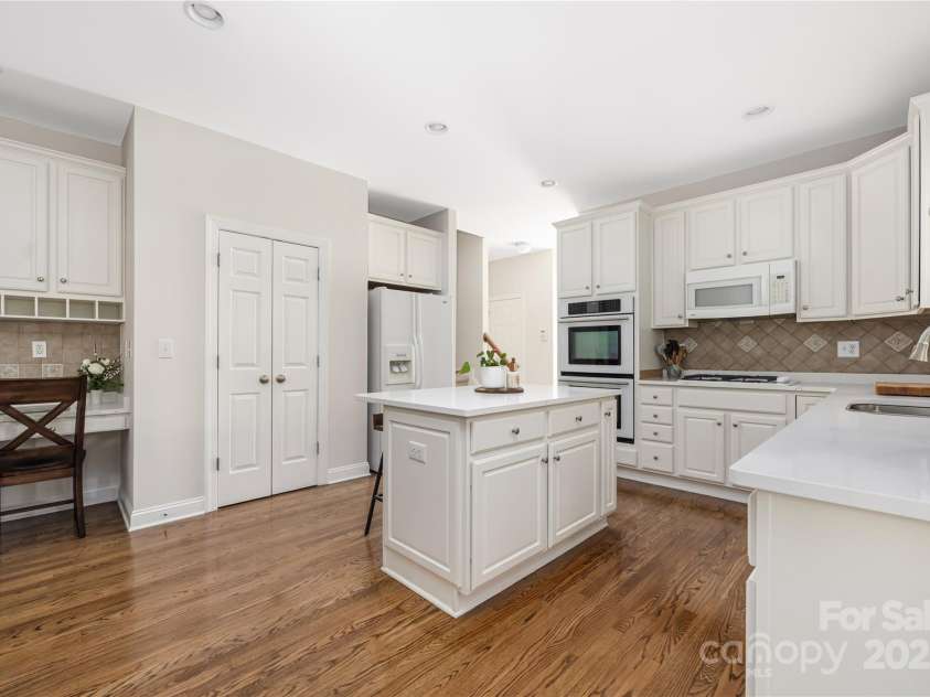 9603 Devonshire Drive, Huntersville, NC 28078.  MLS# CAR4292851, YatesRealty ID 35141. Double wall oven.  Pantry to the left of the refrigerator.  Island has power source and bar seating for two.