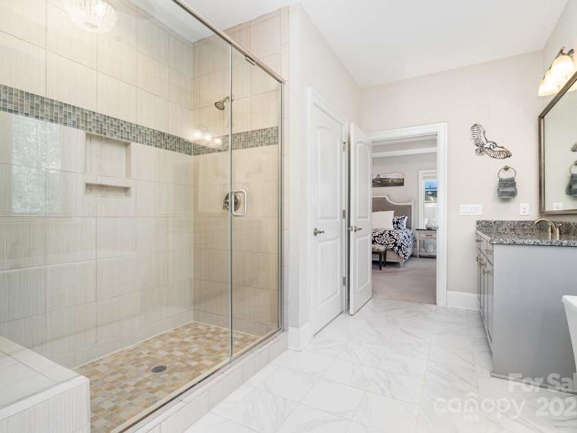 6211 Jepson Court, Charlotte, NC 28214.  MLS# CAR4293083, YatesRealty ID 35158. Custom tiled primary bathroom shower with built in bench.