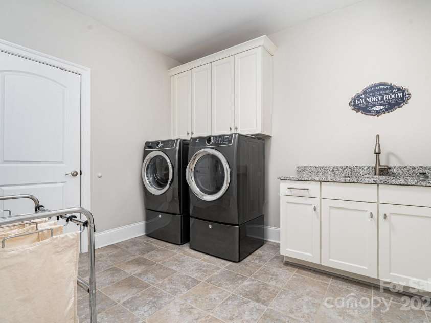 6211 Jepson Court, Charlotte, NC 28214.  MLS# CAR4293083, YatesRealty ID 35158. Upstairs laundry room complete with built in cabinetry and utility sink.