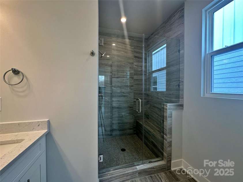 2035 Clarksdale Drive, Charlotte, NC 28206.  MLS# CAR4227622, YatesRealty ID 35165. Frameless Glass Door and Ceiling Height Tile in the Owner's Shower