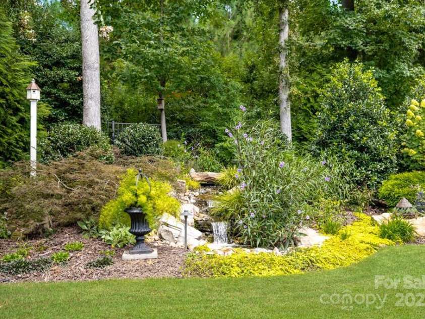 825 Spelman Drive, Indian Land, SC 29707.  MLS# CAR4289548, YatesRealty ID 35229. Rear Fenced Yard with Landscaping and Serene Water Feature