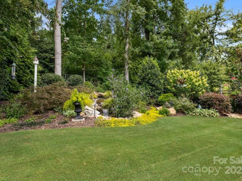 825 Spelman Drive, Indian Land, SC 29707.  MLS# CAR4289548, YatesRealty ID 35229. Rear Fenced Yard with Landscaping and Serene Water Feature