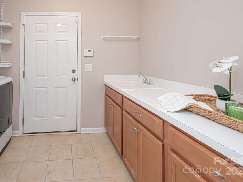 1045 Princeton Drive, Indian Land, SC 29707.  MLS# CAR4286861, YatesRealty ID 35232. Large laundry room with sink and cabinets