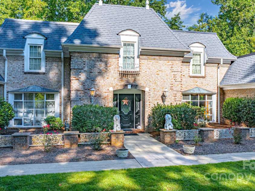 390 Forest Heights Drive, Marion, NC 28752.  MLS# CAR4295653, YatesRealty ID 35233. Classic touches that blend French influence with Southern traditional style. Decorative elements include the balcony railing above the entrance, ornamental lamps, and stone lion statues bring in elegance and a sense 
