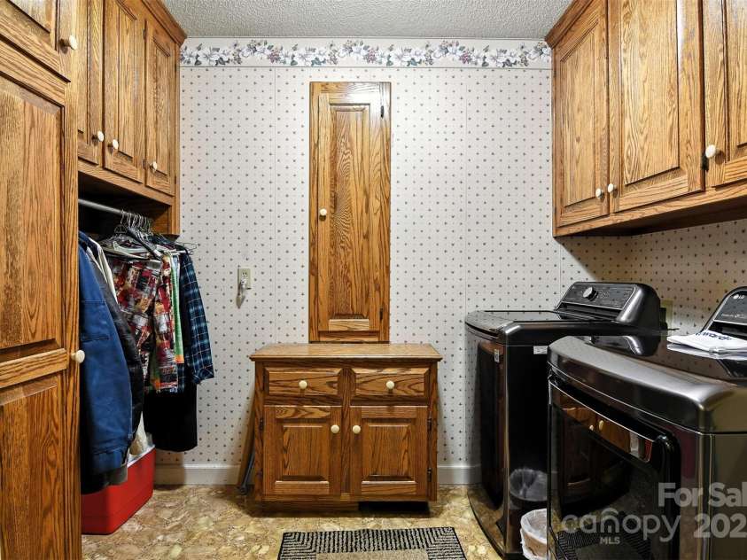 530 5th Street, Hickory, NC 28601.  MLS# CAR4289321, YatesRealty ID 353. Laundry with oak cabinets, hanging bar and hidden ironing board