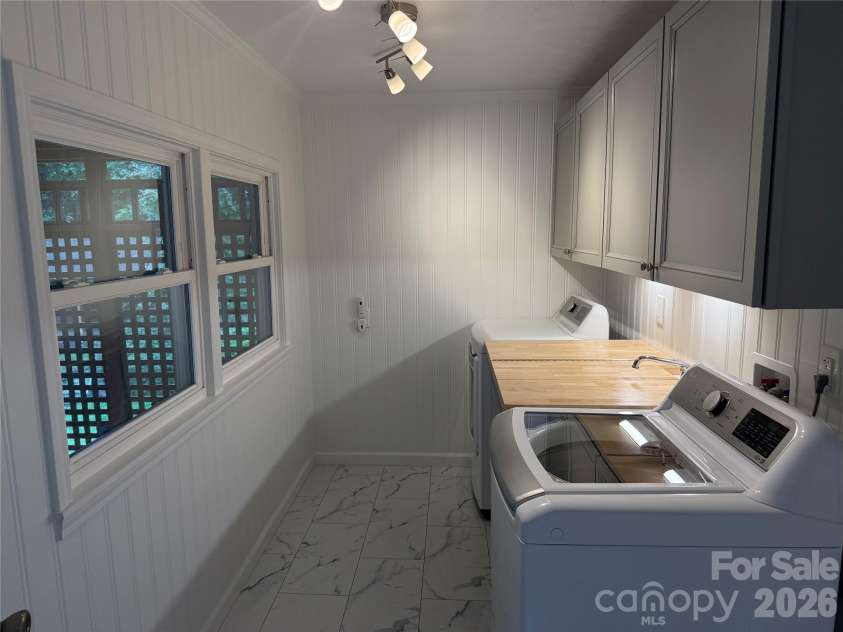 32 Mayfair Drive, Candler, NC 28715.  MLS# CAR4392323, YatesRealty ID 35365. Laundry room w/sink, folding area, cabinets.
