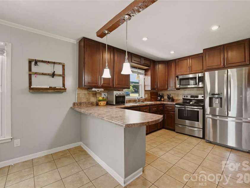 520 Eastway Avenue, Kannapolis, NC 28083.  MLS# CAR4396055, YatesRealty ID 35385. Remodeled kitchen featuring stainless steel appliances and a tile backsplash.