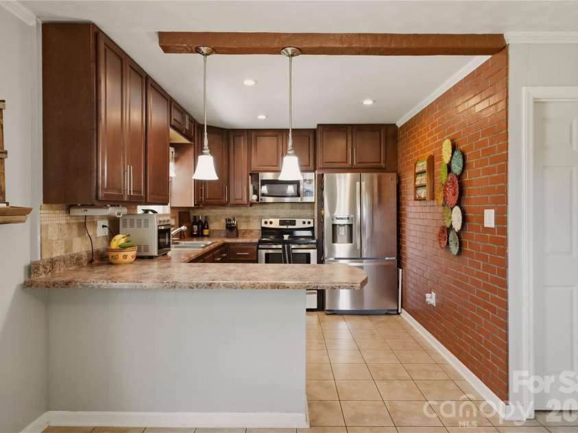 520 Eastway Avenue, Kannapolis, NC 28083.  MLS# CAR4396055, YatesRealty ID 35385. Remodeled kitchen featuring stainless steel appliances and a tile flooring and backsplash.