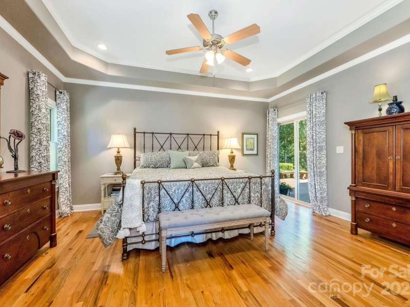 101 Cabana Drive, Mooresville, NC 28117.  MLS# CAR4293731, YatesRealty ID 35535. Spacious primary with treyed ceiling and sliding doors to covered back deck.