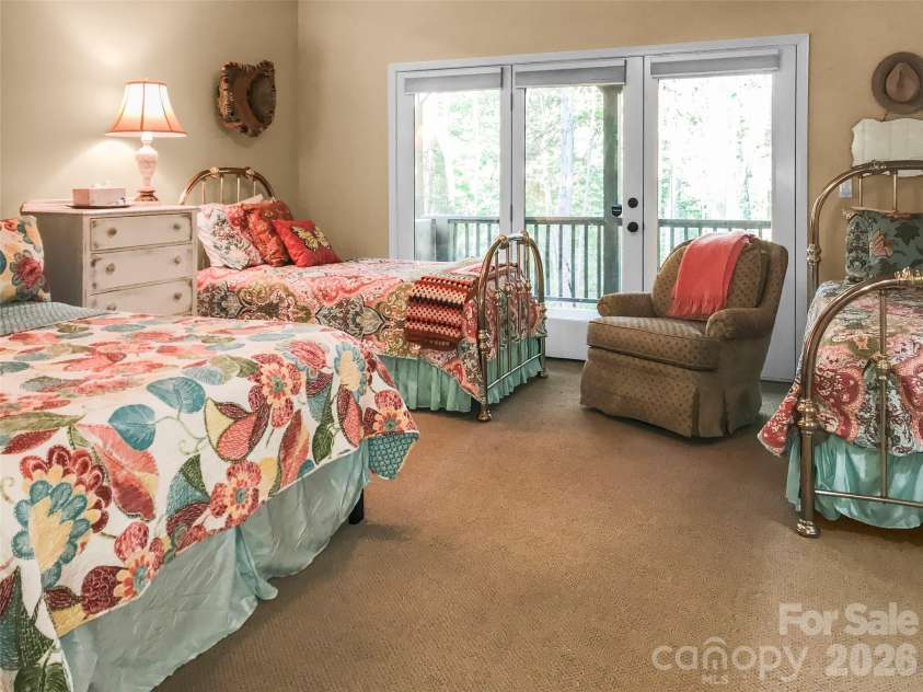 435 Stepping Stone Lane, Waynesville, NC 28786.  MLS# CAR4399751, YatesRealty ID 35549. Lower level primary bedroom 1 view 1 opens to private deck.