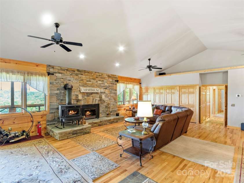 263 Wolf Mountain Road, Green Mountain, NC 28740.  MLS# CAR4148202, YatesRealty ID 3574. Living room w/gas fireplace & woodburning stove