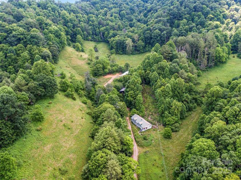 263 Wolf Mountain Road, Green Mountain, NC 28740.  MLS# CAR4148202, YatesRealty ID 3574. Pasture & barns adjacent to older farmhouse on lower portion of property