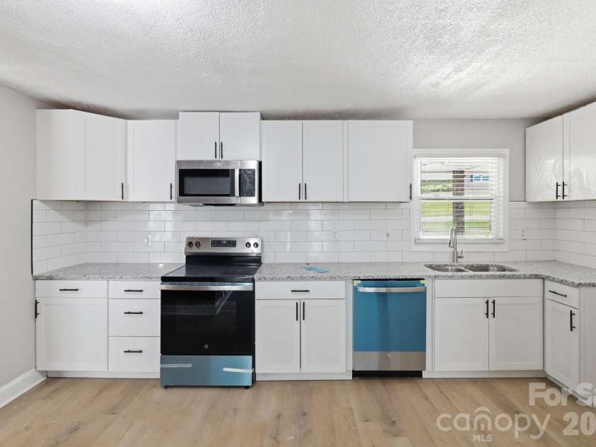 4800 Westridge Drive, Charlotte, NC 28208.  MLS# CAR4400257, YatesRealty ID 35976. Walking into your updated kitchen. Highlights include granite counters, tons of shaker-style cabinetry, SS appliances (includes dishwasher, electric range & microwave), subway tile backsplash & SS dual deep sink.