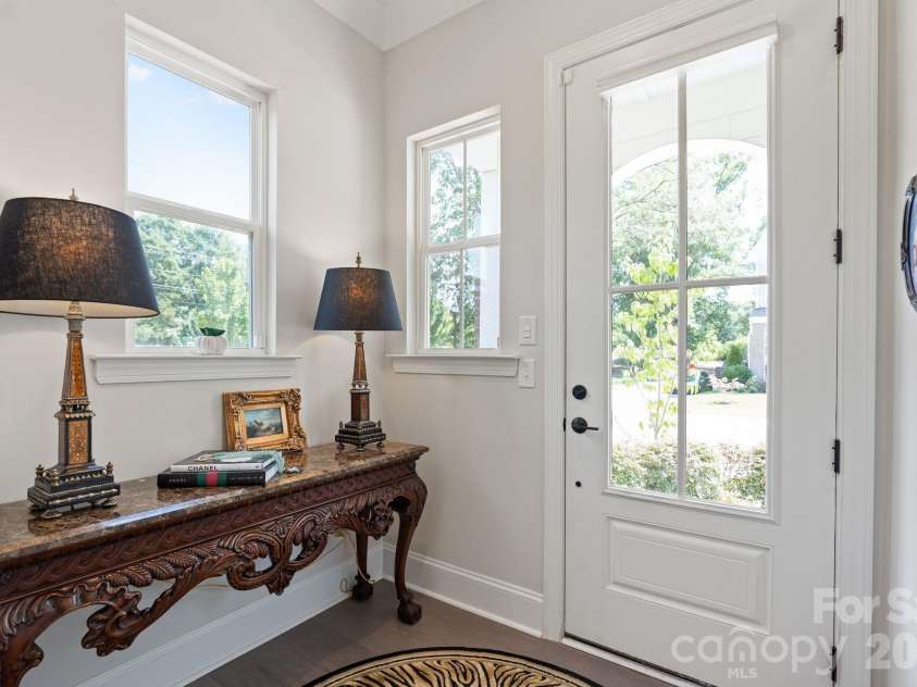 4135 Merkland Lane, Charlotte, NC 28226.  MLS# CAR4401079, YatesRealty ID 36090. Light-filled foyer with glass-paned front door and luxury LVP flooring flowing throughout the main level of this South Charlotte townhome.