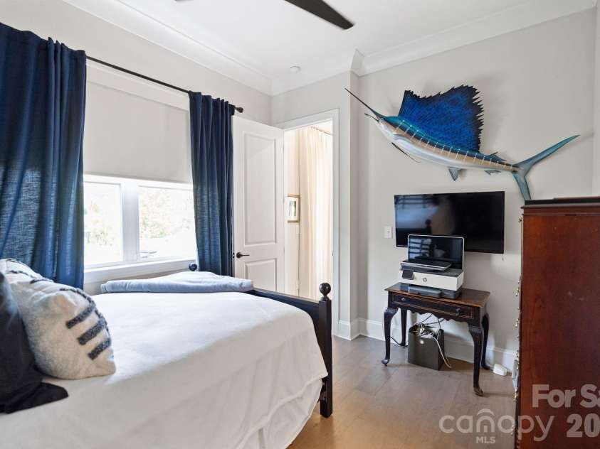 4135 Merkland Lane, Charlotte, NC 28226.  MLS# CAR4401079, YatesRealty ID 36090. Serene 1st floor guest bedroom with plush carpet, large windows and electric shades — comfortable private space in this 4-bedroom Kenley townhome.