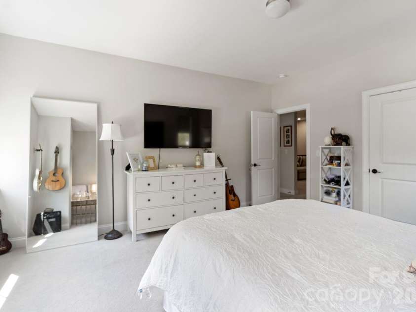 4135 Merkland Lane, Charlotte, NC 28226.  MLS# CAR4401079, YatesRealty ID 36090. Spacious bedroom with plush carpet and generous natural light — flexible living for guests or multigenerational households in Kenley, South Charlotte.