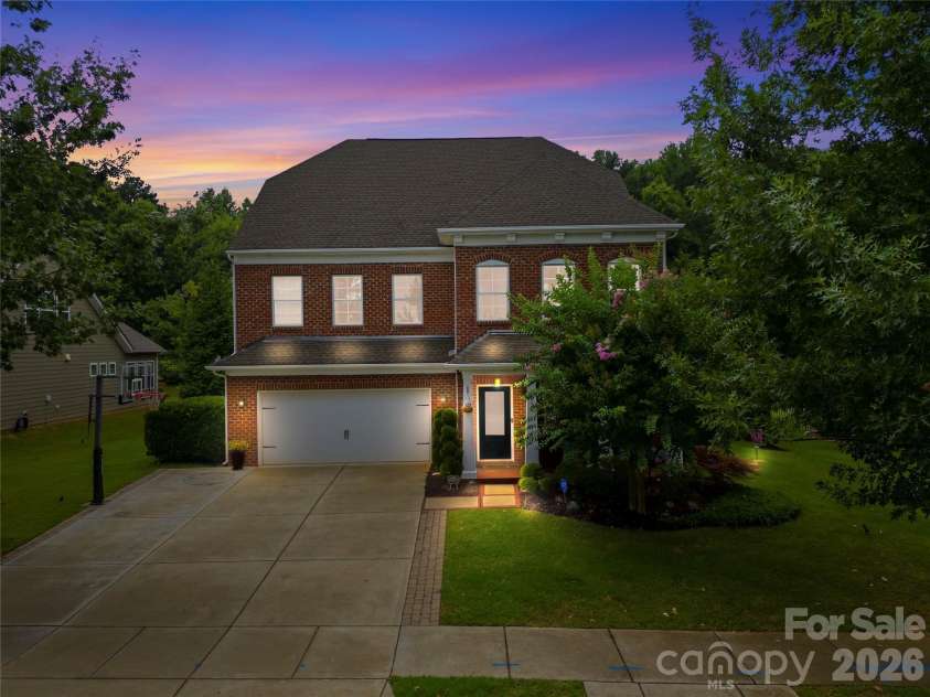 14336 Baytown Court, Huntersville, NC 28078.  MLS# CAR4399744, YatesRealty ID 36107. Beautiful evening exterior highlights the home's timeless architecture and professional landscape lighting.