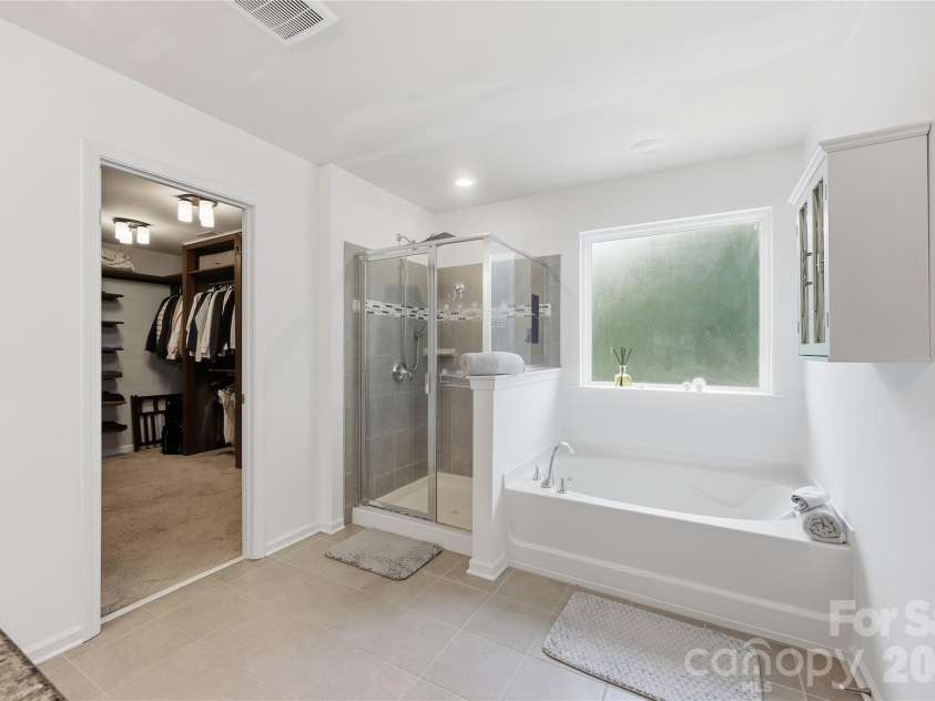 14336 Baytown Court, Huntersville, NC 28078.  MLS# CAR4399744, YatesRealty ID 36107. Luxurious primary bath features a soaking tub, frameless glass shower, and direct access to the custom walk-in closet.