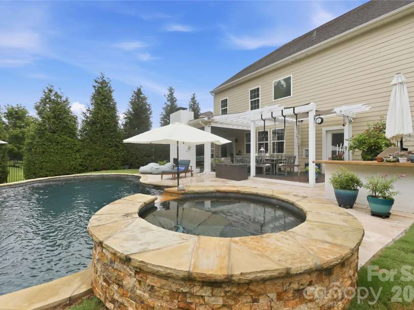 14336 Baytown Court, Huntersville, NC 28078.  MLS# CAR4399744, YatesRealty ID 36107. Relax year-round in the raised spa overlooking the pool and backyard retreat.