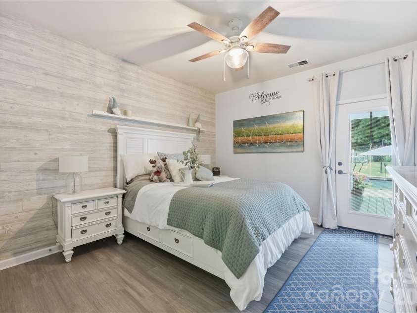 14336 Baytown Court, Huntersville, NC 28078.  MLS# CAR4399744, YatesRealty ID 36107. Spacious guest suite on the main level with custom wood-paneled accent wall and water-resistant bamboo flooring.