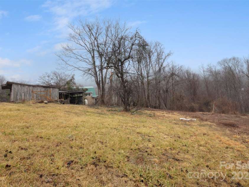 255 & 257 Crescent Street, Saluda, NC 28773.  MLS# CAR4218749, YatesRealty ID 3613. View of the Animal Run-in and side of three car garage.