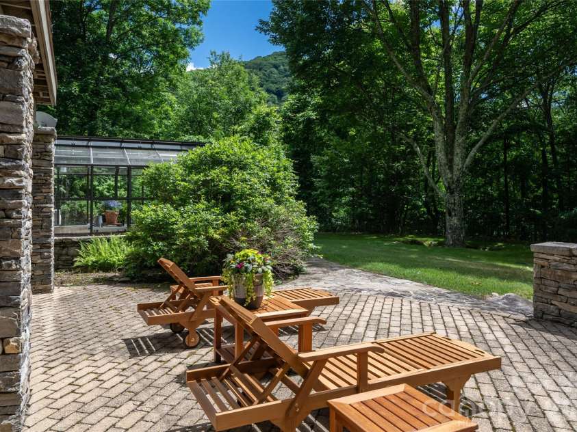4900 Preserve Road, Sylva, NC 28779.  MLS# CAR4393548, YatesRealty ID 36172. Lower veranda with flat yard and beatuiful blend of pavers and flagstone