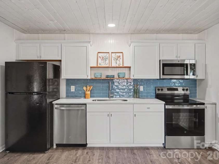 105 Mcgee Street, Fort Mill, SC 29715.  MLS# CAR4393320, YatesRealty ID 36210. Beautiful blue backsplash, open shelving, white cabinetry, custom ceiling.