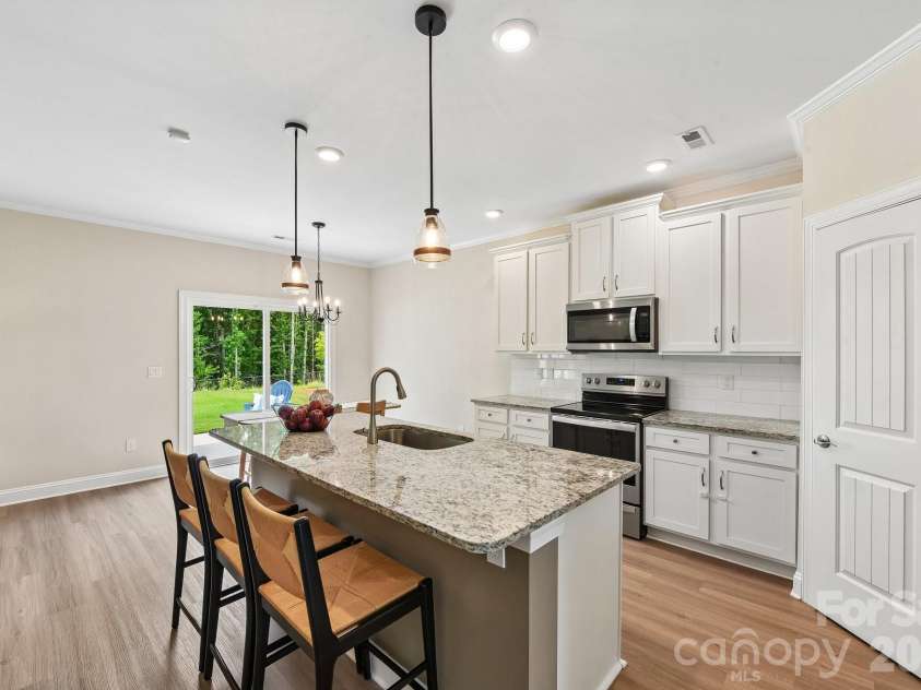 148 Tanner Loop, Troutman, NC 28166.  MLS# CAR4401637, YatesRealty ID 36232. Kitchen features granite, subway tile, and updated fixtures.