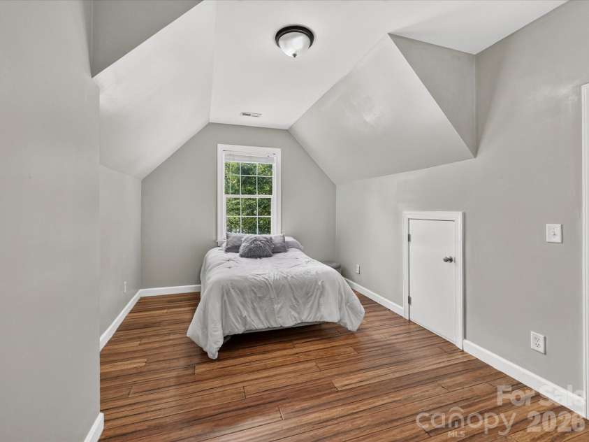 18625 The Commons Boulevard, Cornelius, NC 28031.  MLS# CAR4397710, YatesRealty ID 36310. Bedroom 2 offers a spacious layout with vaulted ceilings, abundant natural light, and a large closet, creating a comfortable retreat for family or guests.