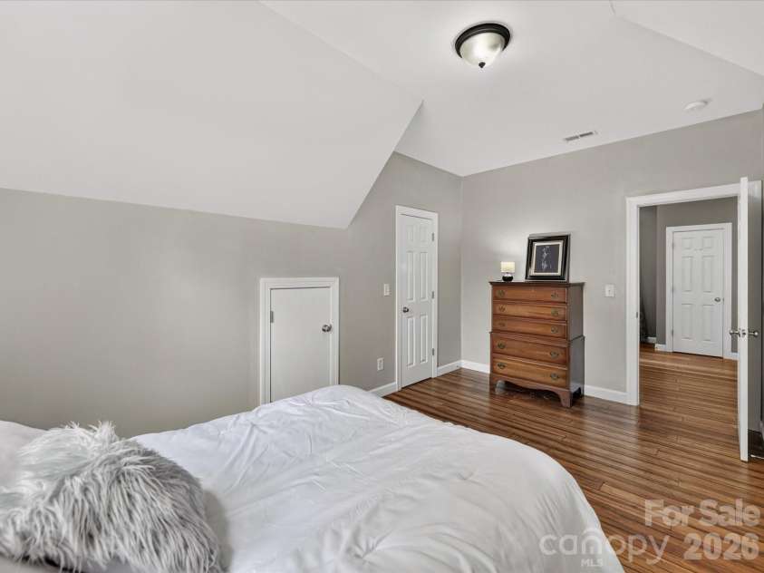 18625 The Commons Boulevard, Cornelius, NC 28031.  MLS# CAR4397710, YatesRealty ID 36310. Bedroom 2 offers a spacious layout with vaulted ceilings, abundant natural light, and a large closet, creating a comfortable retreat for family or guests.