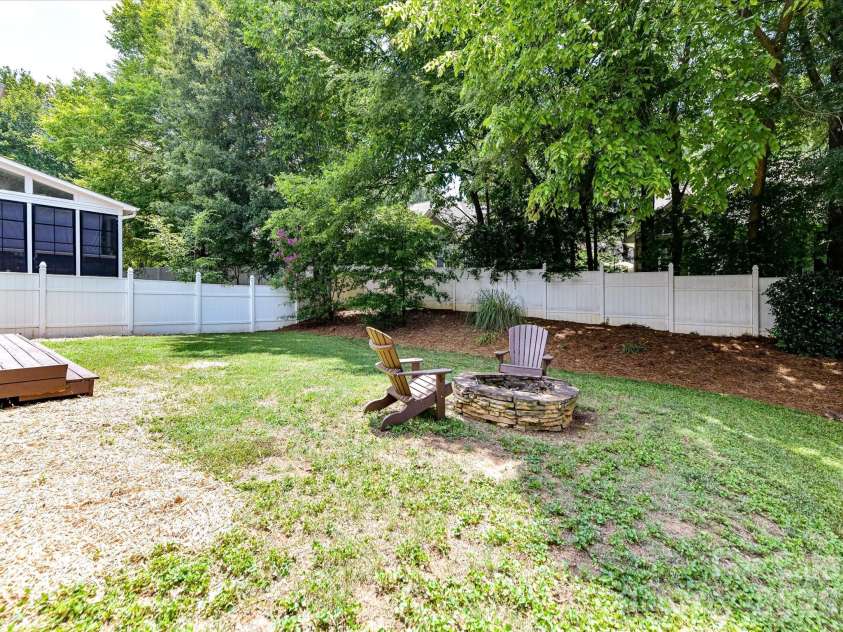 18625 The Commons Boulevard, Cornelius, NC 28031.  MLS# CAR4397710, YatesRealty ID 36310. Gather around the inviting fire pit in the private, fully fenced backyard, offering a peaceful outdoor retreat surrounded by mature trees and plenty of space to relax or entertain.
