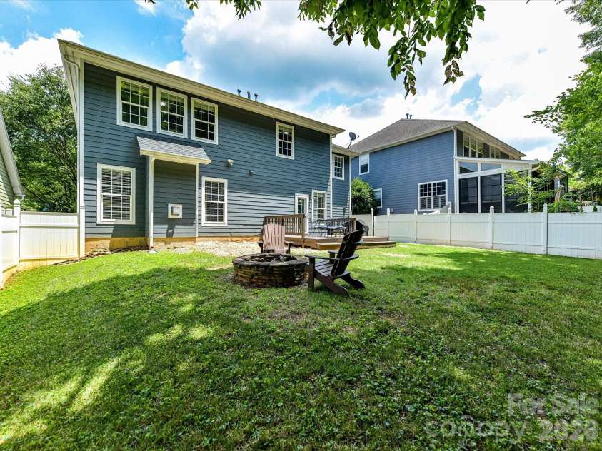 18625 The Commons Boulevard, Cornelius, NC 28031.  MLS# CAR4397710, YatesRealty ID 36310. Gather around the inviting fire pit in the private, fully fenced backyard, offering a peaceful outdoor retreat surrounded by mature trees and plenty of space to relax or entertain.