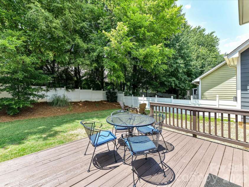 18625 The Commons Boulevard, Cornelius, NC 28031.  MLS# CAR4397710, YatesRealty ID 36310. Step outside onto the spacious back deck overlooking the private, fully fenced backyard, creating the perfect setting for outdoor dining, entertaining, or relaxing among the mature trees.