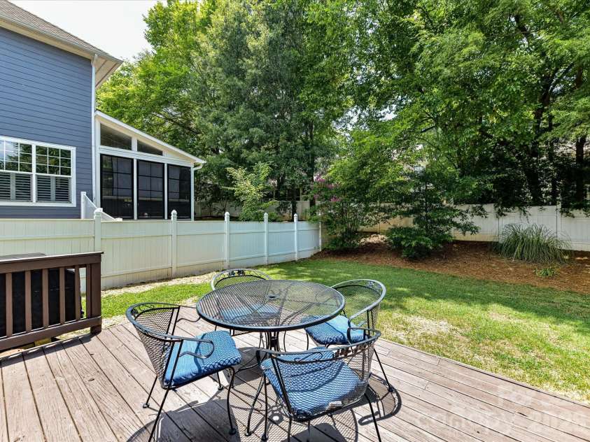 18625 The Commons Boulevard, Cornelius, NC 28031.  MLS# CAR4397710, YatesRealty ID 36310. Step outside onto the spacious back deck overlooking the private, fully fenced backyard, creating the perfect setting for outdoor dining, entertaining, or relaxing among the mature trees.