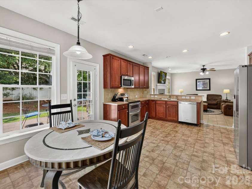 18625 The Commons Boulevard, Cornelius, NC 28031.  MLS# CAR4397710, YatesRealty ID 36310. The bright kitchen and adjoining breakfast nook offer the perfect setting for casual meals, featuring stainless steel appliances, abundant cabinetry, and direct access to the backyard for seamless indoor-outdoo